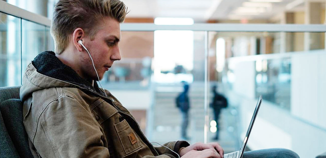 Student on laptop with earbuds